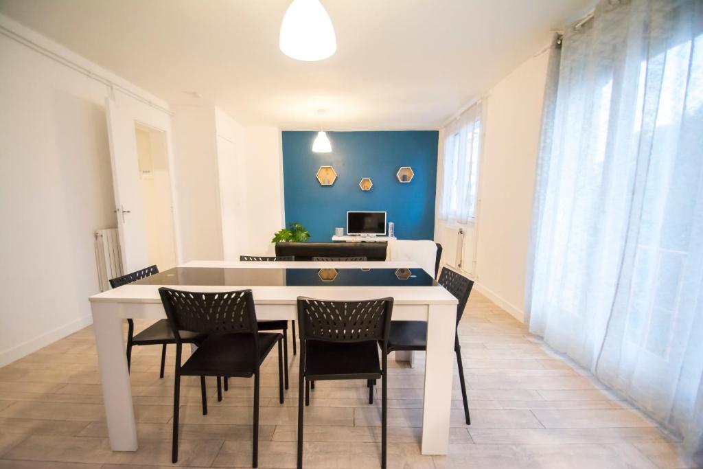 a dining room with a white table and chairs at Appartement hypercentre Tarbes in Tarbes