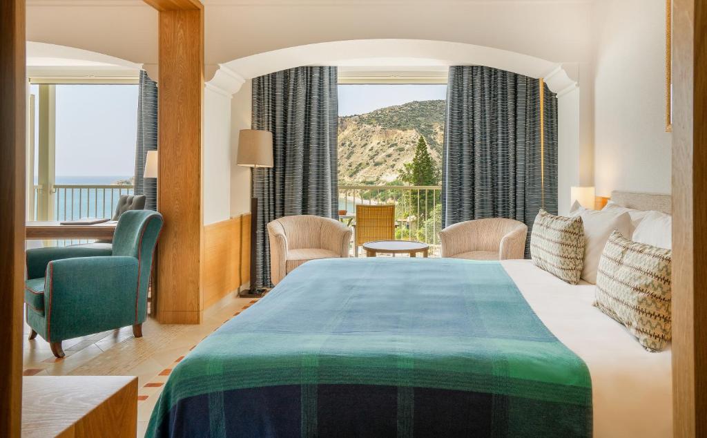 a hotel room with a bed and a large window at Columbia Beach Resort in Pissouri