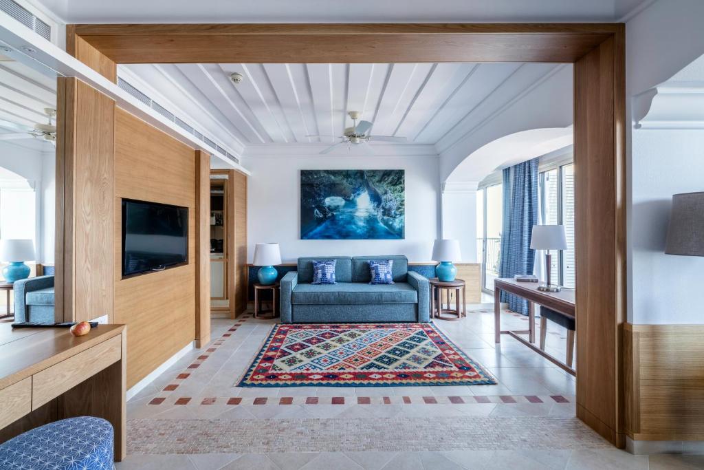 a living room with a couch and a tv at Columbia Beach Resort in Pissouri