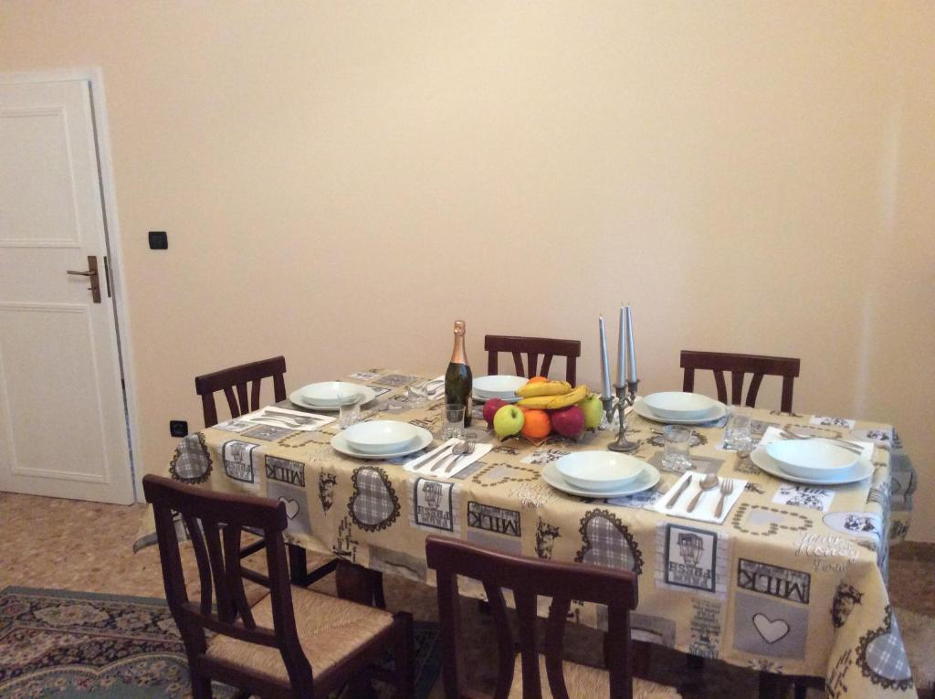stół jadalny z butelką wina i owocami w obiekcie Gene Holiday Home w Rawennie