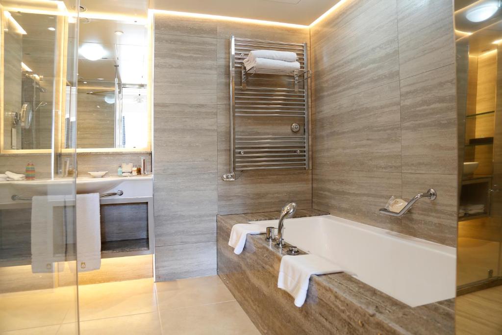 a bathroom with a bath tub and a sink at Columbia Beach Resort in Pissouri