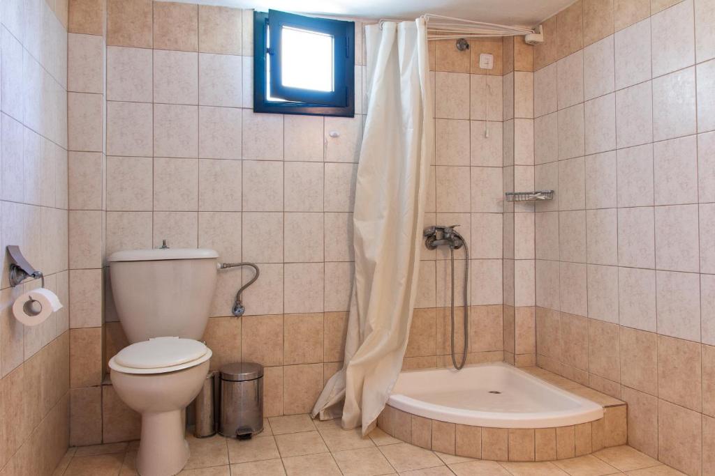 W łazience znajduje się toaleta, prysznic i wanna. w obiekcie Estia Studios w mieście Kriopigi