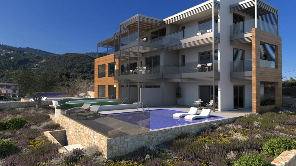 a building with a swimming pool in front of it at Amira in Skiathos Town