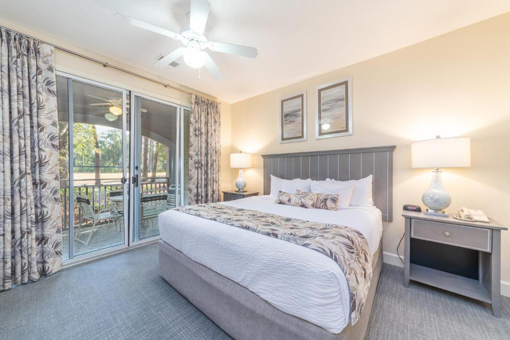 a bedroom with a large bed and a balcony at Island Links Resort by Palmera in Hilton Head Island