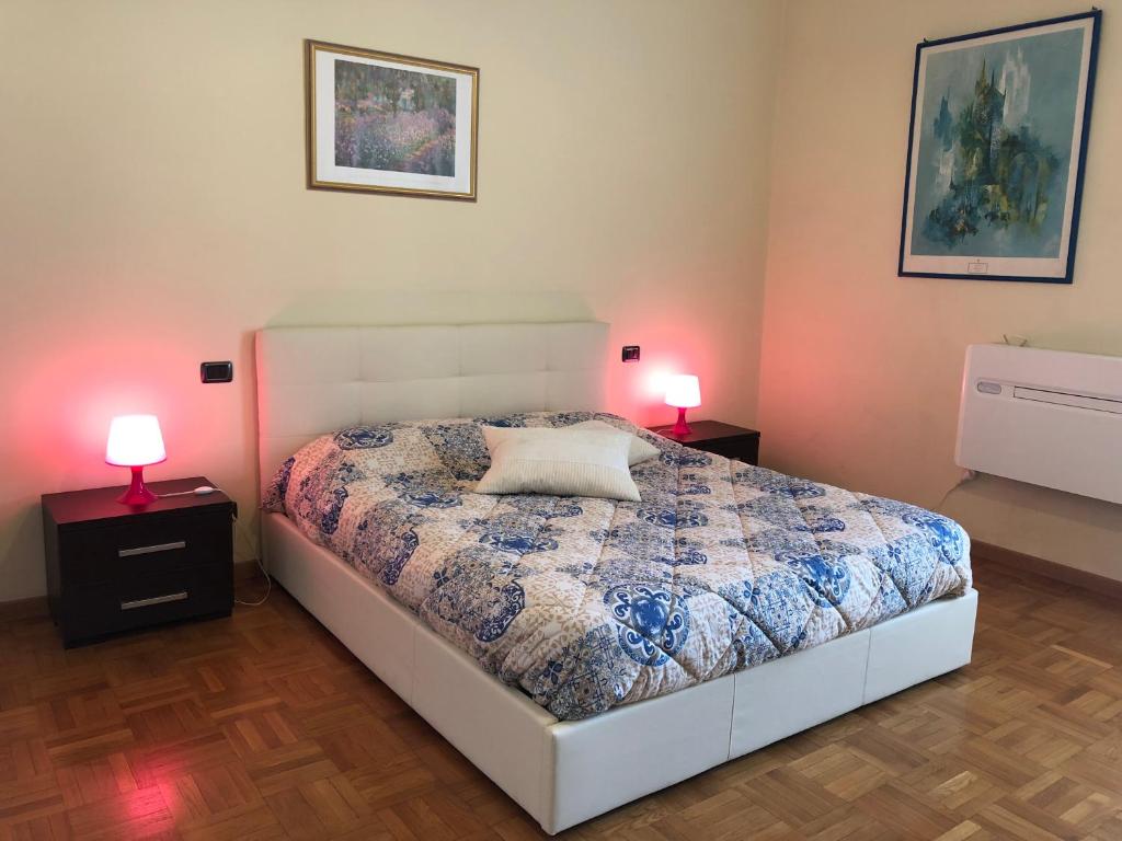 フィレンツェにある3 Perle all'Accademia Apartmentsのベッドルーム1室(ベッド1台付)、2泊分のスタンド(ランプ付)