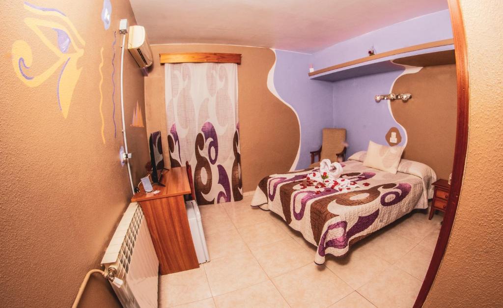 een kleine kamer met een bed en een raam bij Hostal La Rosa in Cáceres