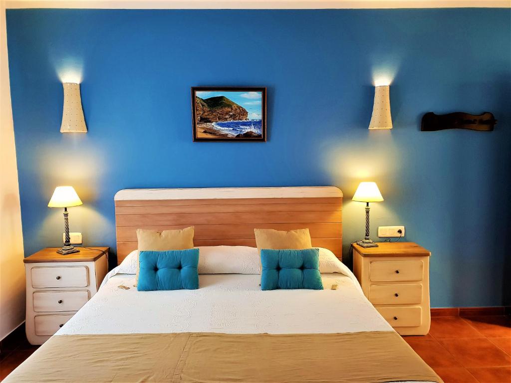 a blue bedroom with a large bed with blue walls at Hotel las Calas in Agua Amarga