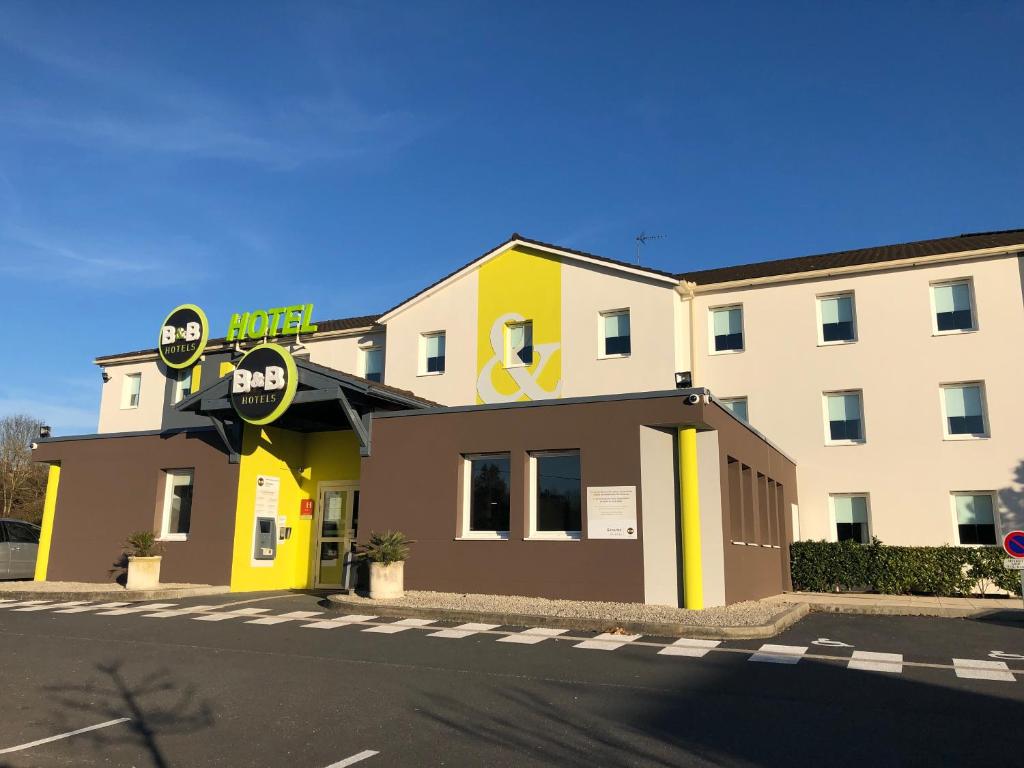 a building with a sign on the side of it at B&B HOTEL Brive-la-Gaillarde in Ussac