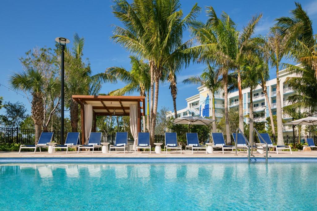 a swimming pool with lounge chairs and palm trees at The Gates Hotel Key West in Key West