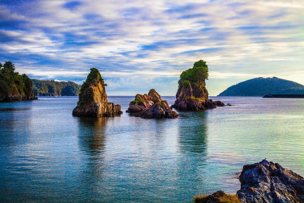a group of rocks in a body of water at Apartamento Playa de Covas in Viveiro
