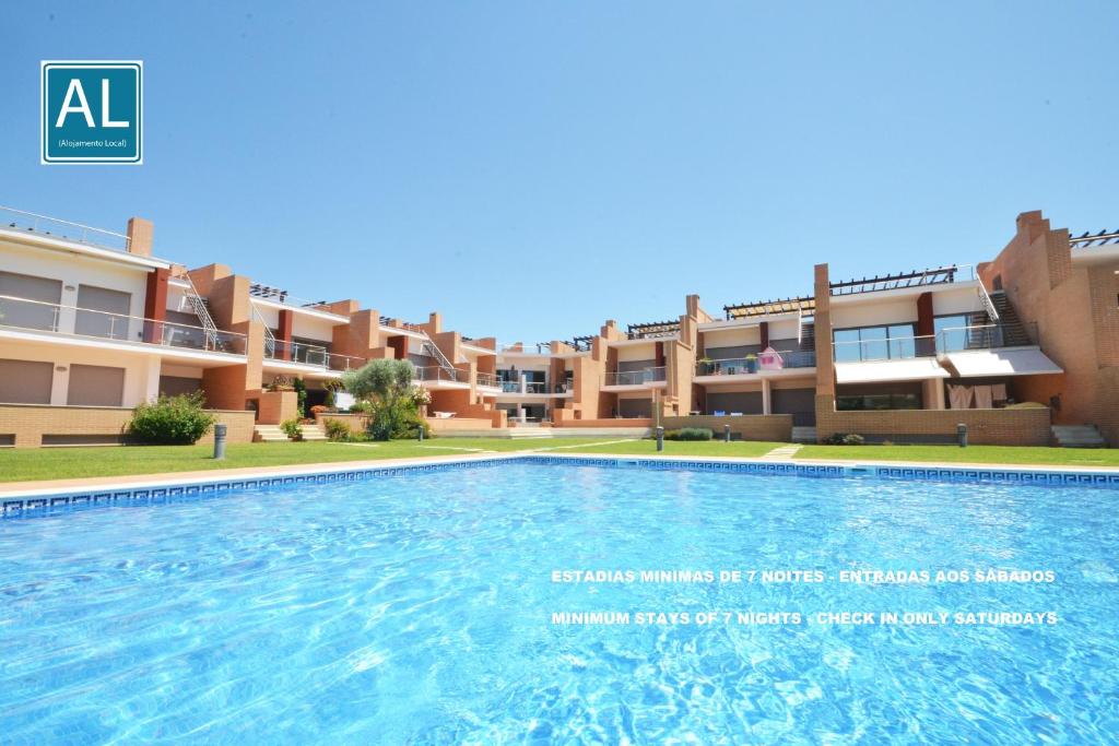 an image of a swimming pool in front of a building at Millennium Golf Residences in Vilamoura