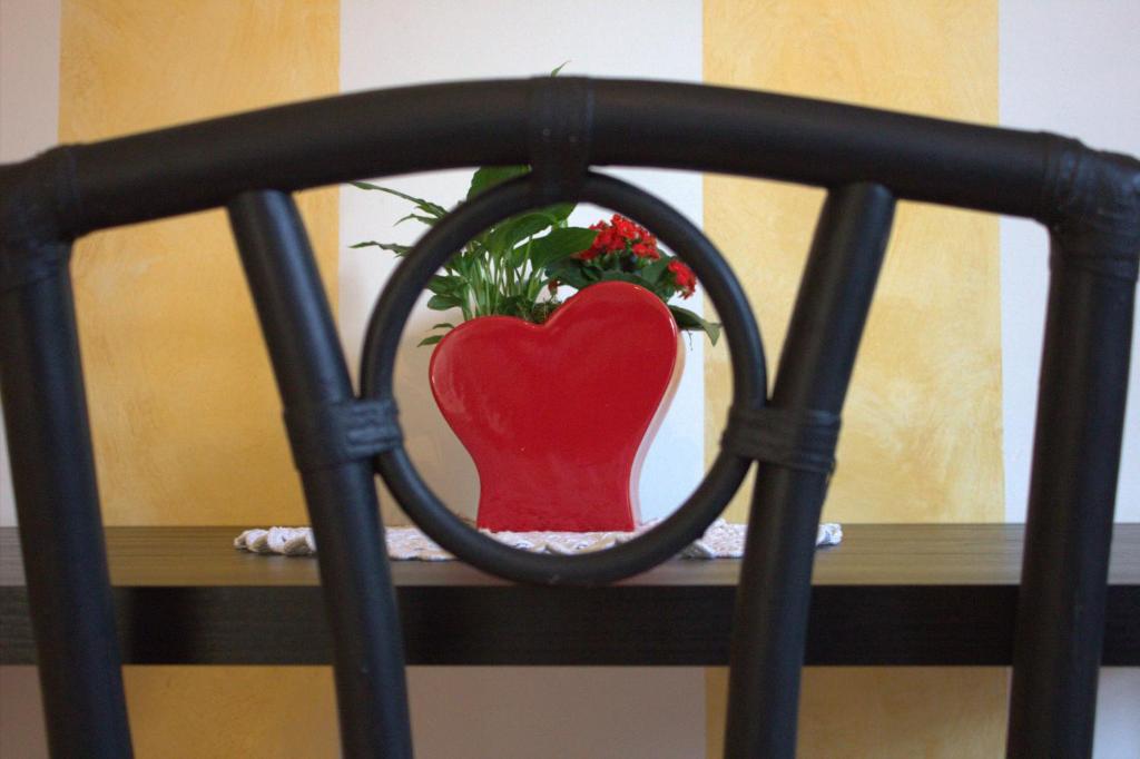 a red heart vase sitting on top of a table at FiumicinoA57 in Fiumicino