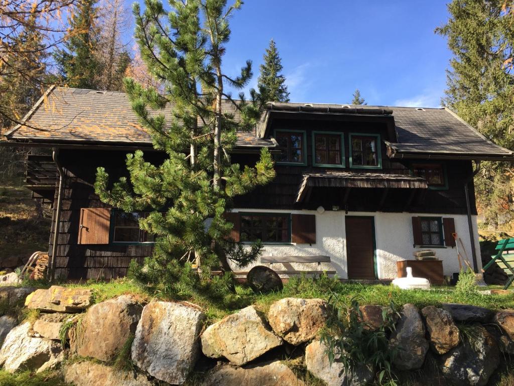 una casa con un árbol delante de ella en Waldnerhütte, en Hermagor