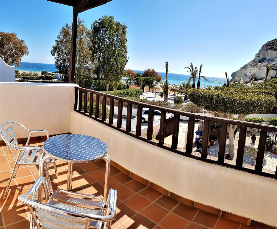 a patio with a table and chairs on a balcony at Hotel las Calas in Agua Amarga