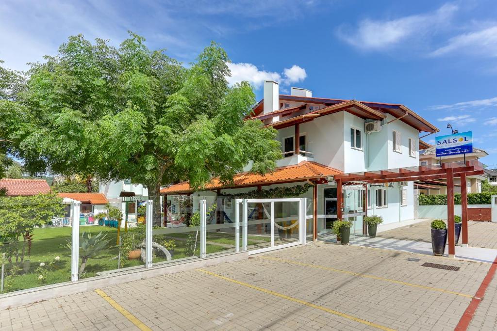 un edificio con un árbol delante de él en Flat Salsol, en Florianópolis