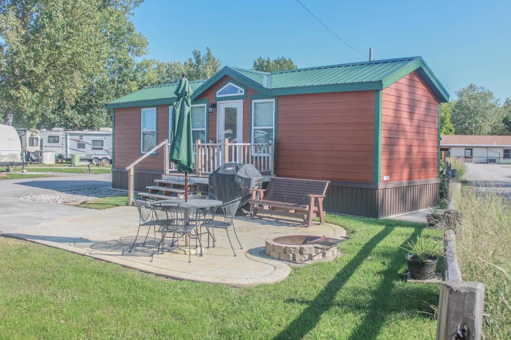 a tiny house with a picnic table and a patio at Sandusky KOA Holiday Campground in Sandusky