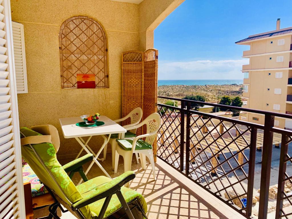 een balkon met een tafel en stoelen en uitzicht bij Sea view Apartament in La Mata