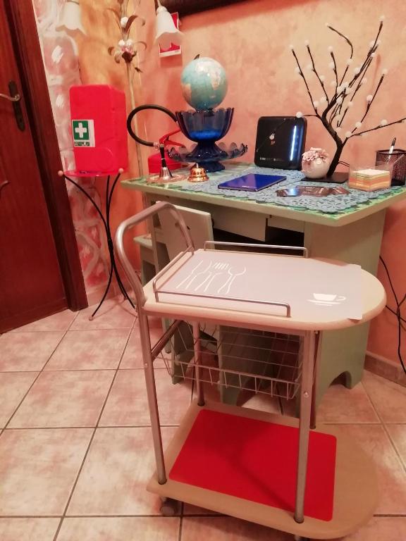a desk with a chair and a table with a laptop at B&B melody in Fiumicino