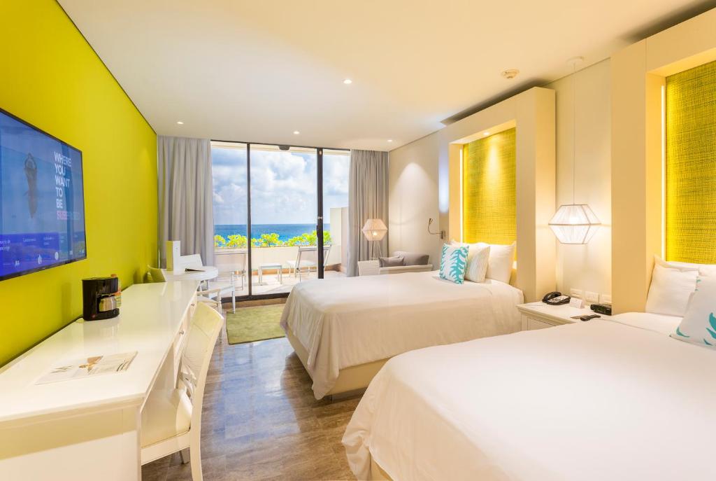 a hotel room with two beds and a large window at Paradisus Cancun All Inclusive in Cancún