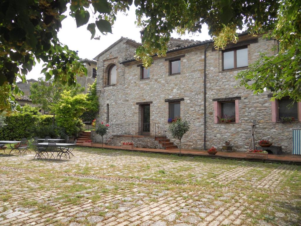 CastelraimondoにあるIl Giardino Degli Uliviの大きな石造りの家で、正面にパティオがあります。