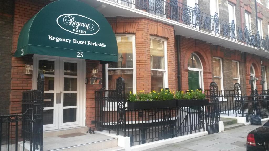فندق ريجنسي باركسايد في لندن: مطعم به مظلة خضراء على مبنى
