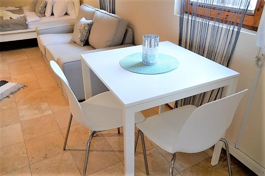 una mesa blanca y sillas en una sala de estar con sofá en Downtown Apartments DeLuxe, en Győr