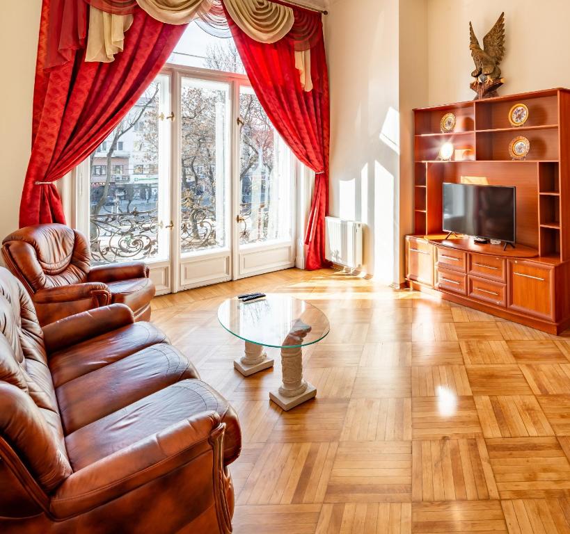 un soggiorno con divano e tavolo in vetro di Grand Lviv Apartment I (1 of 3) a Lviv