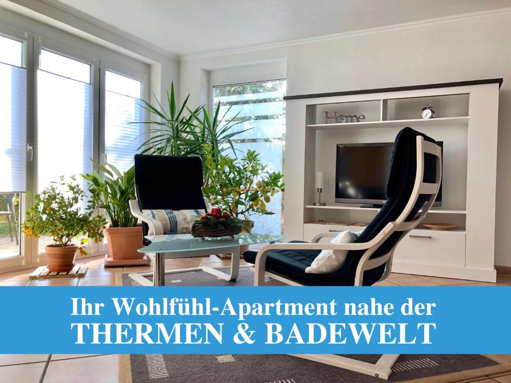 een woonkamer met een tv en 2 stoelen bij Apartment Casa del Monte in Sinsheim
