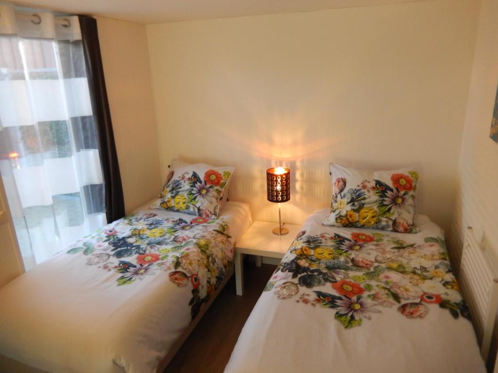 1 dormitorio con 2 camas y mesa con lámpara en Apartment Amsterdam New West - Free parking, en Ámsterdam