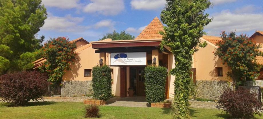 a house with a sign in the front yard at Hosteria Sueños Dorados in Merlo