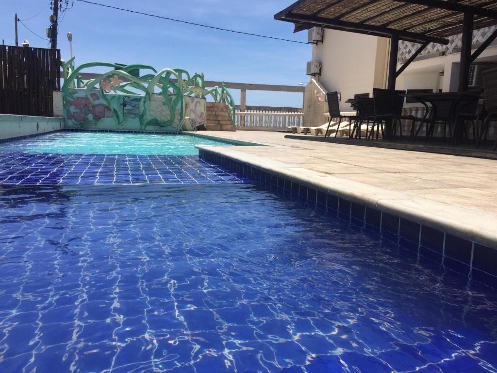 a swimming pool with blue water in a house at Eden Praia Hotel in Porto Seguro
