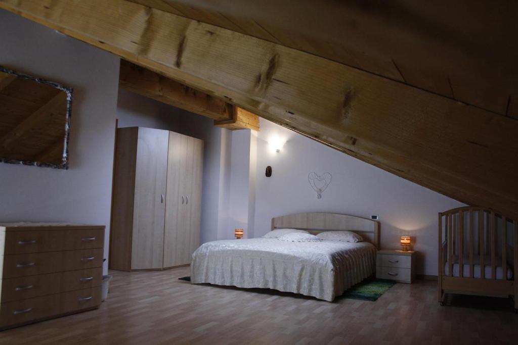 a bedroom with a bed and a wooden ceiling at Appartamento Al Castello in Levico Terme