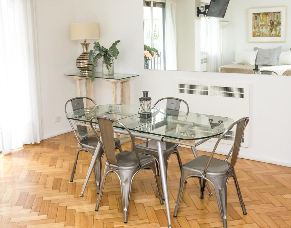 una mesa de cristal y sillas en la sala de estar. en Optimus BA | Arenales en Buenos Aires