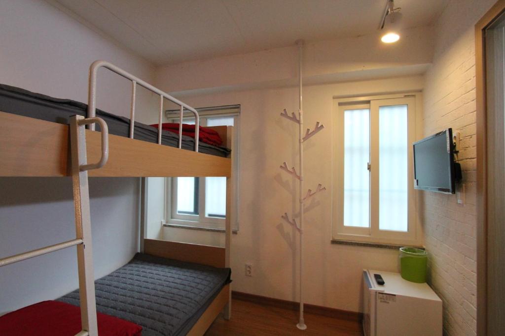 ソウルにあるビー マイ ゲストハウスの二段ベッド1組、テレビが備わる小さな客室です。