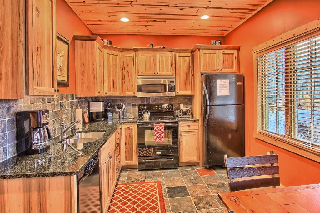 a kitchen with wooden cabinets and a stainless steel refrigerator at Edelweiss Lodge in Boyne Falls