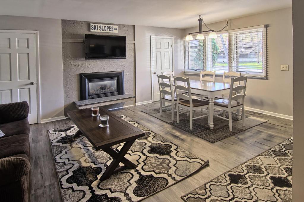 ein Wohnzimmer mit einem Tisch und einem Kamin in der Unterkunft Boyne Mountain Villa in Boyne Falls