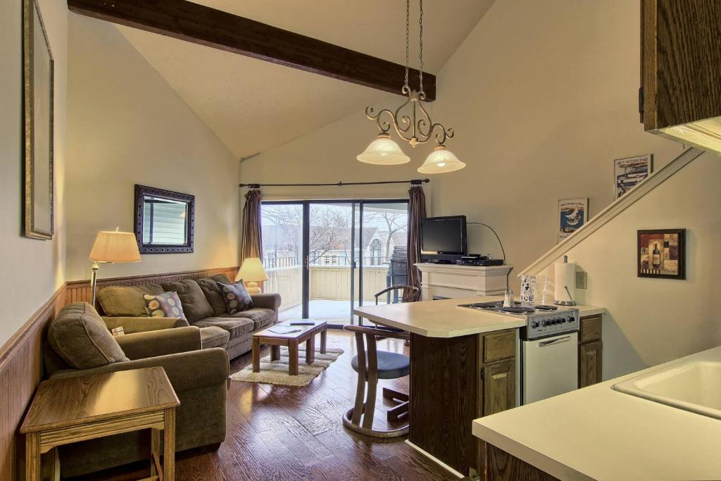 een keuken en een woonkamer met een bank en een tafel bij 209 Pointes North Inn in Charlevoix