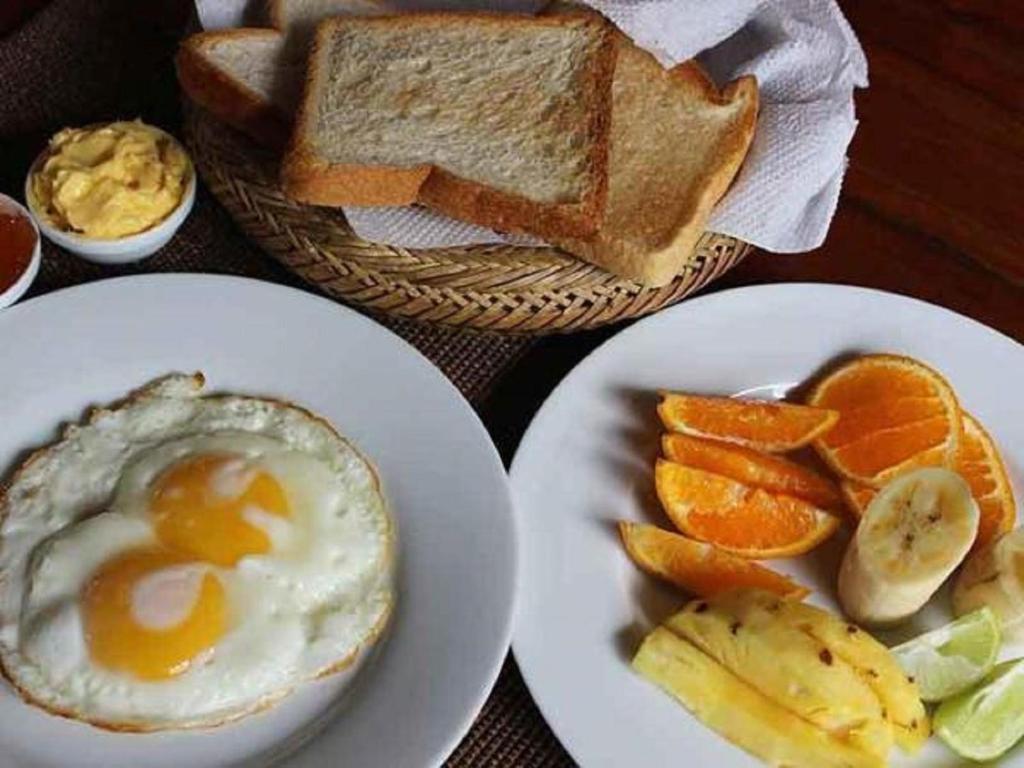 a breakfast plate with an egg and bread and fruit at Grace in Nuwara Eliya