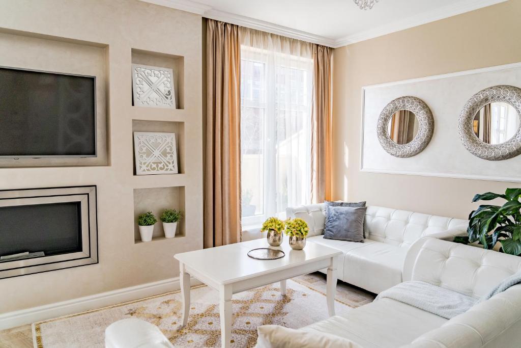 Una sala de estar con un sofá blanco y un televisor. en KApartments, en Varna