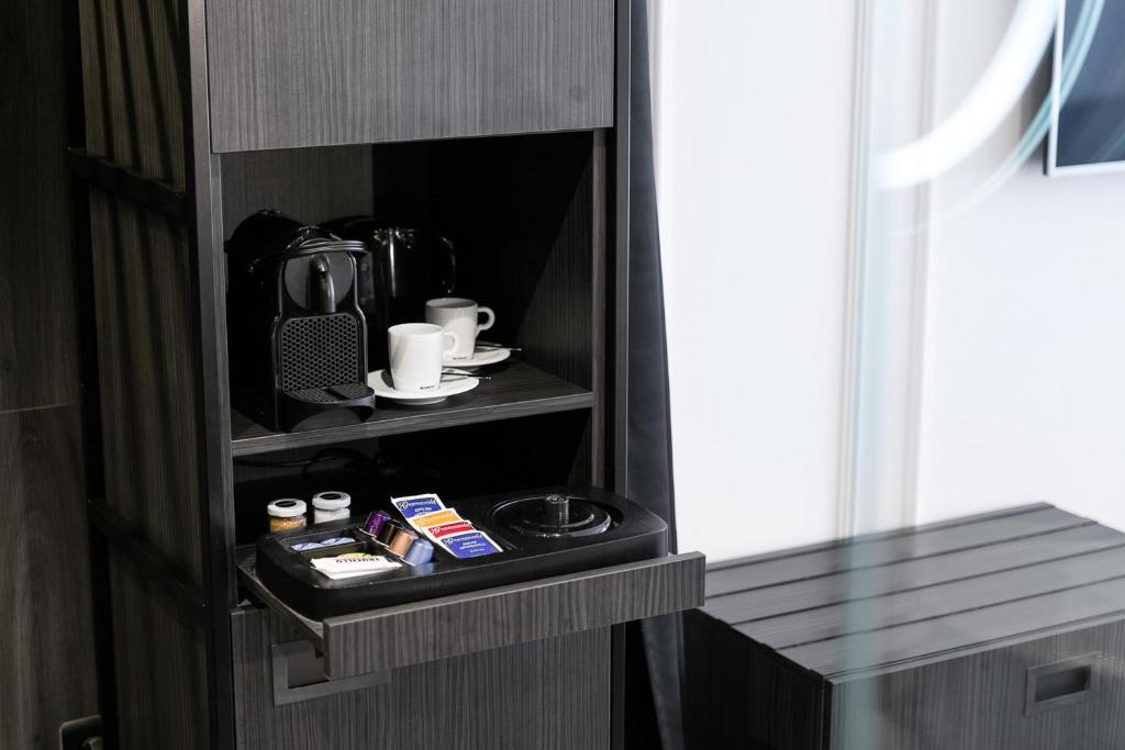 a room with a cupboard with a coffee maker at Pytloun Boutique Hotel Prague in Prague