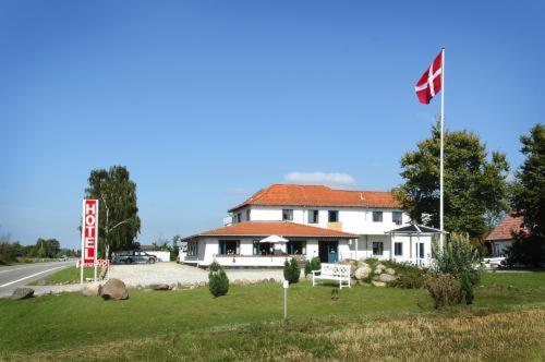 Hotel Medio Fredericia في فردريسيا: بيت ابيض كبير عليه علم