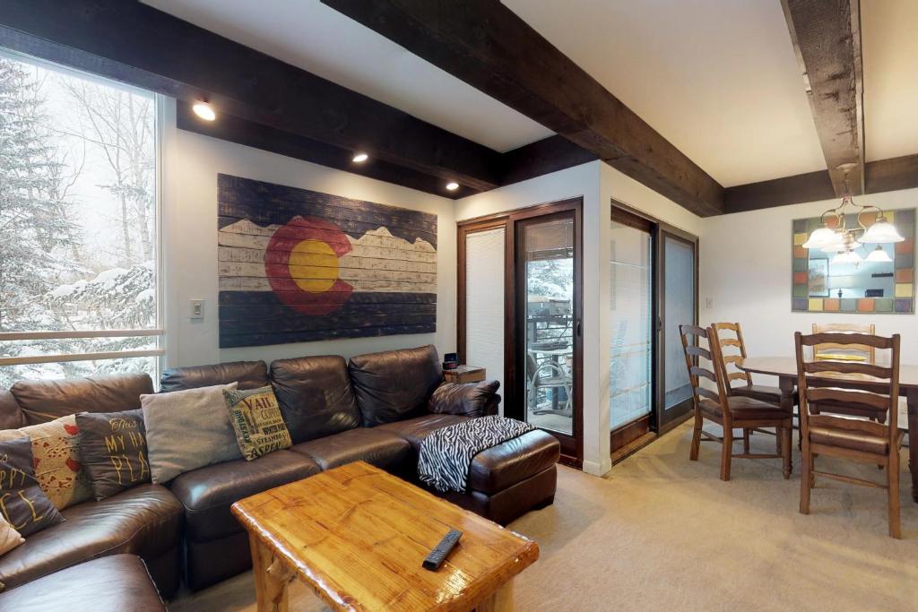 a living room with a leather couch and a table at Lionshead Apartments in Vail