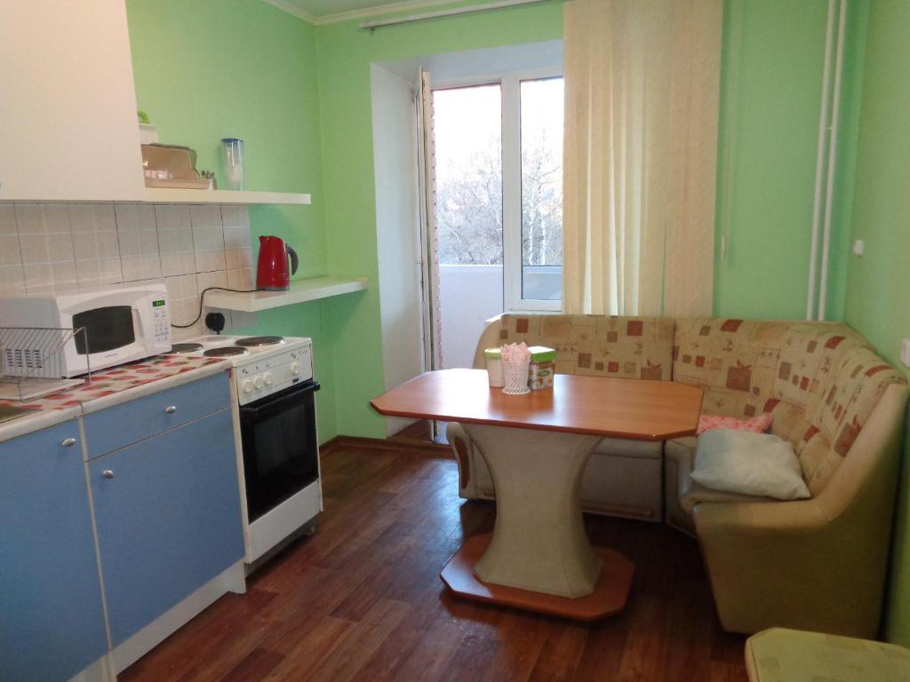 トムスクにあるUchebnaya 7 - 2 Bedroomの小さなキッチン(テーブル、ソファ付)