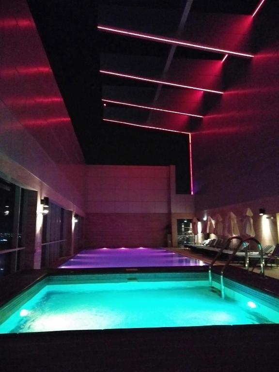 a swimming pool with red lights in a building at Royal M Hotel Fujairah by Gewan in Fujairah
