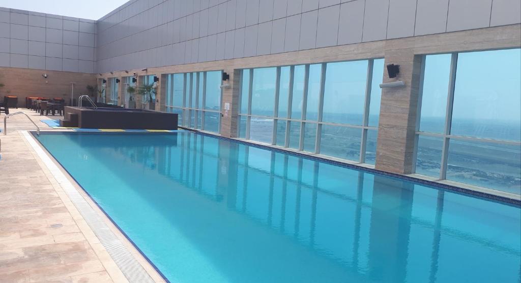 a large swimming pool in a building with windows at Royal M Hotel Fujairah by Gewan in Fujairah