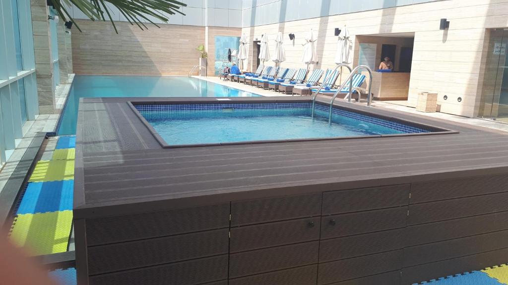 a swimming pool in a building with a swimming pool at Royal M Hotel Fujairah by Gewan in Fujairah