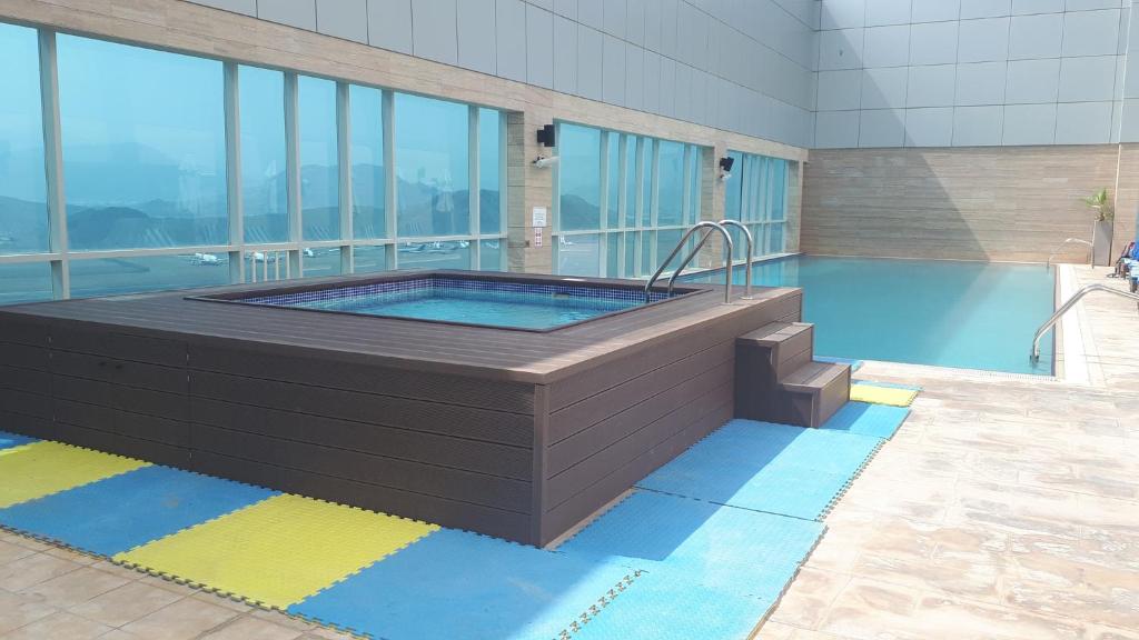 a swimming pool with a hot tub in a building at Royal M Hotel Fujairah by Gewan in Fujairah
