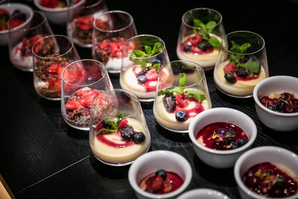 a bunch of dessert dishes in glasses on a table at Pytloun Boutique Hotel Prague in Prague