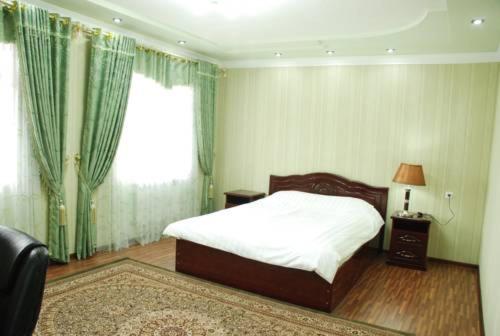 a bedroom with a bed and a window at Toshkent Hotel in Andijan