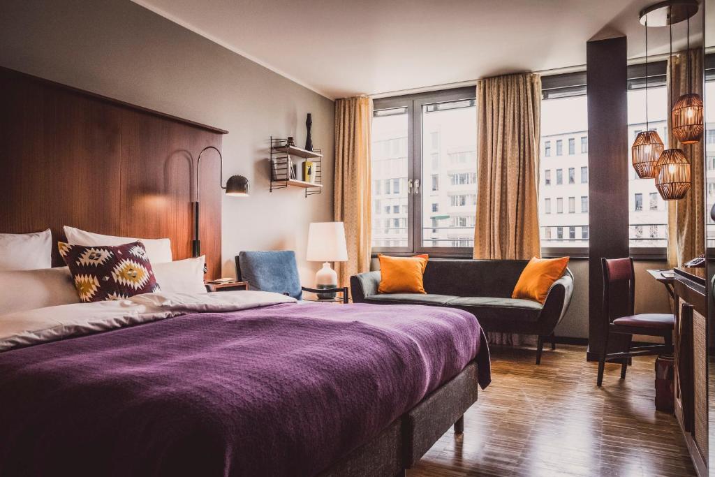 um quarto de hotel com uma cama e um sofá em Henri Hotel Düsseldorf Downtown em Düsseldorf